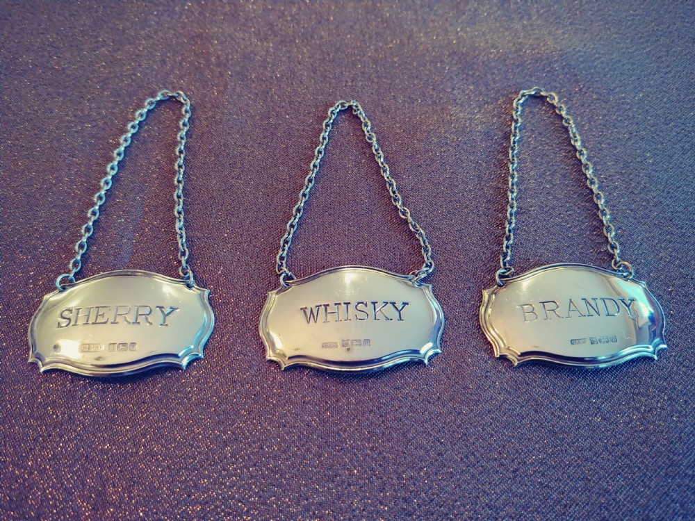 very nice set of three sterling silver matching decanter labels on silver chains
